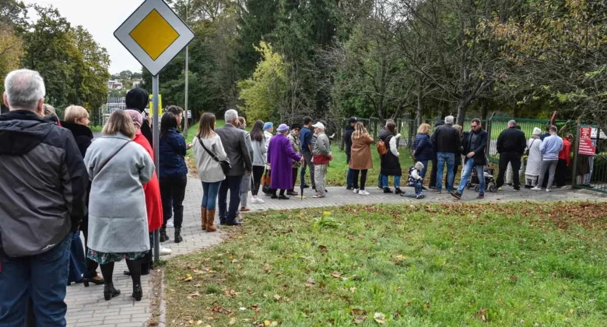 Ludzie stojący w kolejce do lokalu wyborczego. Fot. PAP